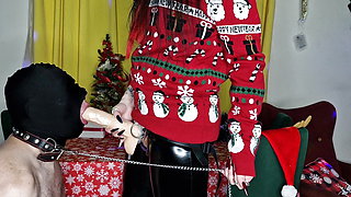 Dominatrix Nika congratulates her slave on Christmas with her big strap-on in his throat.