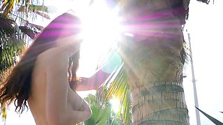 Busty petite MILF strips naked outdoors