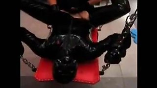 Fucking a slave in latex with a strapon